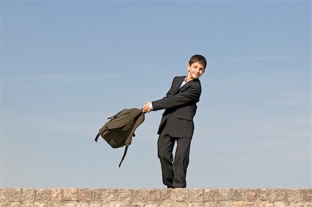 a happy pre-teen is coming back from school holding his schoolbag in his hands Stock Photo - Budget Royalty-Free & Subscription, Code: 400-04141470