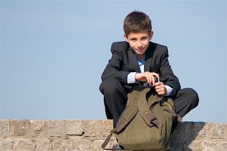 simsearch:400-04643781,k - a successful school student is sitting on the stones and holding his schoolbag in his hands Stock Photo - Budget Royalty-Free & Subscription, Code: 400-04141471