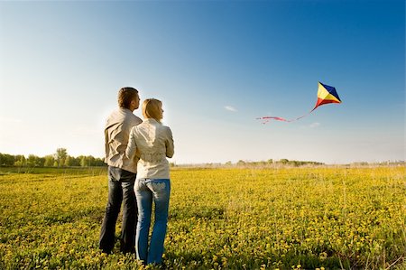 Happy young couple in love flying a kite Fotografie stock - Microstock e Abbonamento, Codice: 400-04143533