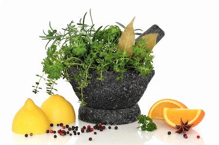 Fresh and dried mixed herb leaf selection in a granite mortar with pestle with lemons oranges, star anise and peppercorns, over white background with reflection. Stock Photo - Budget Royalty-Free & Subscription, Code: 400-04154043