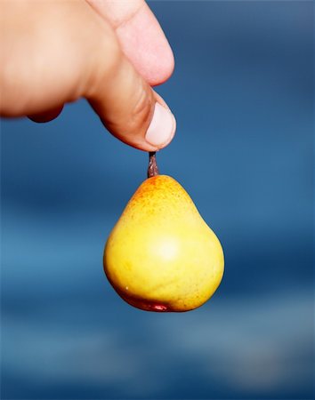simsearch:400-04243170,k - Hand holding a pear over sky background Stock Photo - Budget Royalty-Free & Subscription, Code: 400-04154443