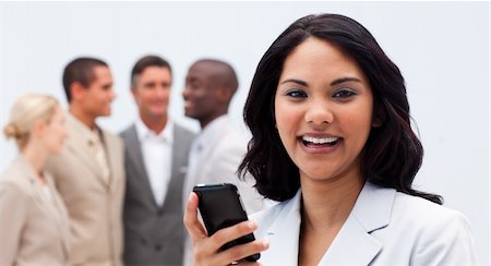 Smiling ethnic businesswoman texting with a mobile phone in workplace Stock Photo - Budget Royalty-Free & Subscription, Code: 400-04154742