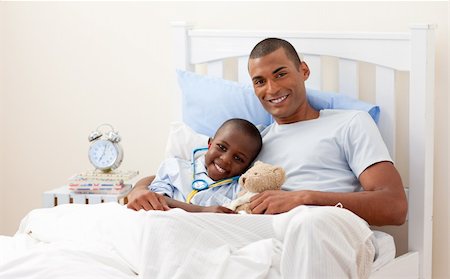 sad african man on bed - Young Father with his sick child in Bed Stock Photo - Budget Royalty-Free & Subscription, Code: 400-04154771