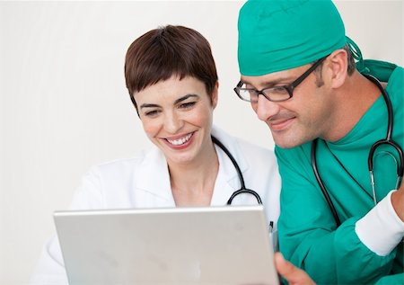 doctor speaking to young patient - Young Doctor and surgeon looking at a laptop Stock Photo - Budget Royalty-Free & Subscription, Code: 400-04154786