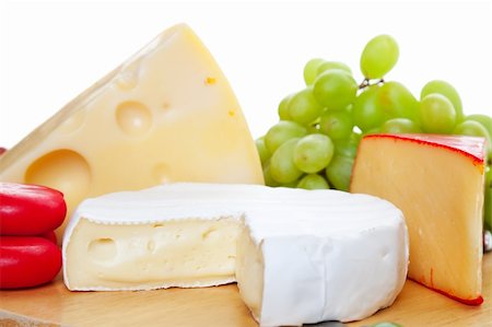 A variety of  cheeses served complimented with green grapes.   Shallow depth of field. Photographie de stock - Aubaine LD & Abonnement, Code: 400-04155563