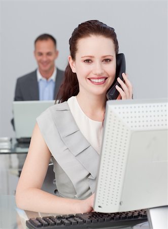 Smiling businesswoman talking on phone and working in the office Foto de stock - Super Valor sin royalties y Suscripción, Código: 400-04156377