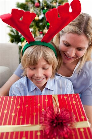Smiling mother and son her opening Christmas present in the living-room Stock Photo - Budget Royalty-Free & Subscription, Code: 400-04156803
