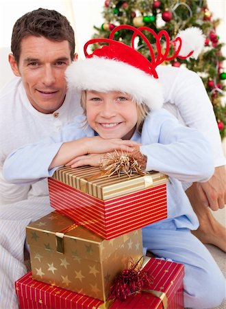 simsearch:400-04147489,k - Portrait of a father and his son holding Christmas presents and sitting on the floor Photographie de stock - Aubaine LD & Abonnement, Code: 400-04156816