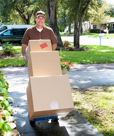 Delivery man or mover pushing a dolly loaded with boxes up the front walk. Foto de stock - Super Valor sin royalties y Suscripción, Código: 400-04156989