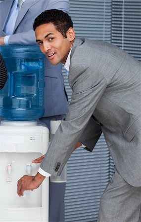 drinking shots - Attractive businessman filling cup from water cooler in the office Stock Photo - Budget Royalty-Free & Subscription, Code: 400-04157432