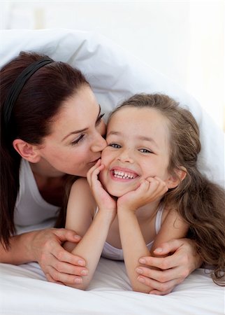 simsearch:400-05749479,k - Mother kissing her daughter lying on bed Foto de stock - Royalty-Free Super Valor e Assinatura, Número: 400-04157486