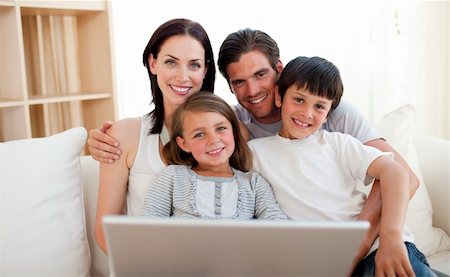 Happy family surfing the internet on the sofa Stock Photo - Budget Royalty-Free & Subscription, Code: 400-04157490