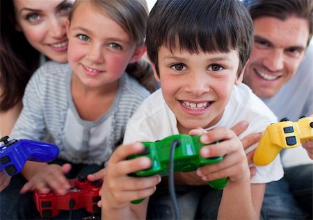 Happy parents and their children playing video games at home Photographie de stock - Aubaine LD & Abonnement, Code: 400-04157493