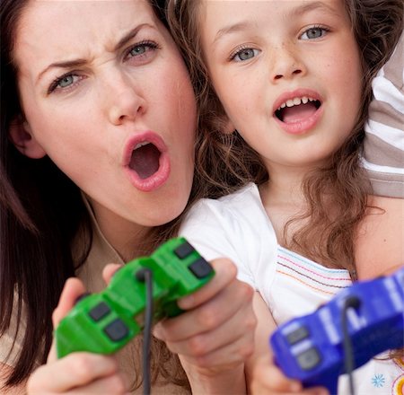 Excited mother and her daughter playing video games at home Stock Photo - Budget Royalty-Free & Subscription, Code: 400-04157545