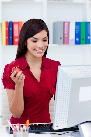 Smiling businesswoman holding a red apple at her desk Stock Photo - Budget Royalty-Free & Subscription, Code: 400-04157698