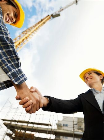 female architect and construction worker shaking hands. Low angle view, copy space Stock Photo - Budget Royalty-Free & Subscription, Code: 400-04158094