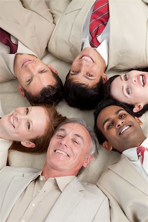 Multi-ethnic business team lying in a circle with heads together Stock Photo - Budget Royalty-Free & Subscription, Code: 400-04159678