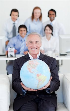 simsearch:400-04187718,k - Smiling businessman holding a terrestrial globe with his team in the background Foto de stock - Royalty-Free Super Valor e Assinatura, Número: 400-04159696