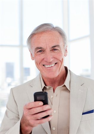Senior businessman using a mobile phone and smiling at the camera Stock Photo - Budget Royalty-Free & Subscription, Code: 400-04159731