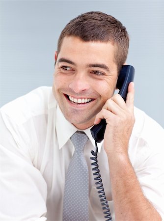 Smiling attractive young businessman in office talking on phone Foto de stock - Super Valor sin royalties y Suscripción, Código: 400-04150612