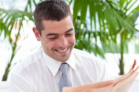 Smiling businessman reading a newspaper in workplace Stock Photo - Budget Royalty-Free & Subscription, Code: 400-04150646