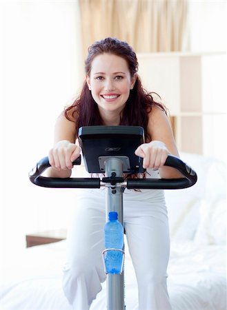 Woman doing spinning bike in her bedroom at home Stock Photo - Budget Royalty-Free & Subscription, Code: 400-04150679