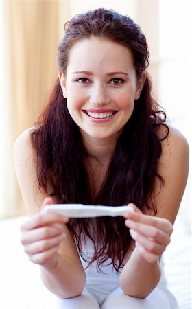 pregnant surprise - Smiling woman holding a pregnancy test in bedroom Stock Photo - Budget Royalty-Free & Subscription, Code: 400-04150688
