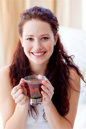 simsearch:693-08127560,k - Smiling woman drinking a cup of tea in bedroom in the morning Stock Photo - Budget Royalty-Free & Subscription, Code: 400-04150691