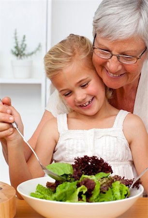 Happy grandmother cooking a salad with granddaughter in the kitchen Stock Photo - Budget Royalty-Free & Subscription, Code: 400-04150716