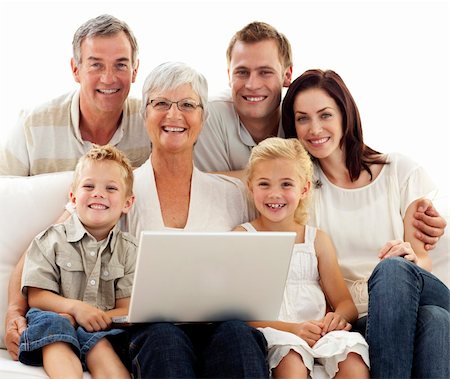 simsearch:400-04575374,k - Smiling family sitting on sofa using a laptop at home Stock Photo - Budget Royalty-Free & Subscription, Code: 400-04150743