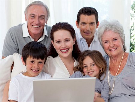 simsearch:400-04575374,k - Portrait of smiling family sitting on sofa using a laptop Stock Photo - Budget Royalty-Free & Subscription, Code: 400-04150758