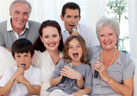 Happy family singing karaoke with microphones in living-room Stock Photo - Budget Royalty-Free & Subscription, Code: 400-04150760