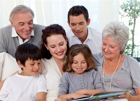 Family sitting on sofa reading a book at home Stock Photo - Budget Royalty-Free & Subscription, Code: 400-04150762