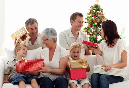 Happy family at home sitting on sofa opening Christmas presents Stock Photo - Budget Royalty-Free & Subscription, Code: 400-04151096