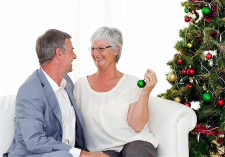 senior woman at christmas parties - Mature couple sitting on sofa with a Christmas tree in the background Stock Photo - Budget Royalty-Free & Subscription, Code: 400-04151105