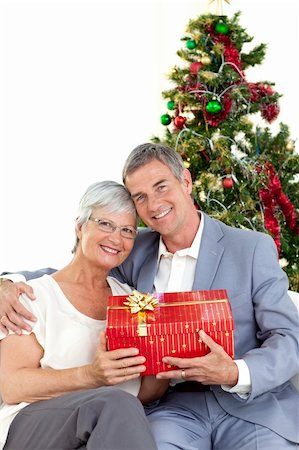 senior woman at christmas parties - Senior couple holding a Christmas present at home Stock Photo - Budget Royalty-Free & Subscription, Code: 400-04151108