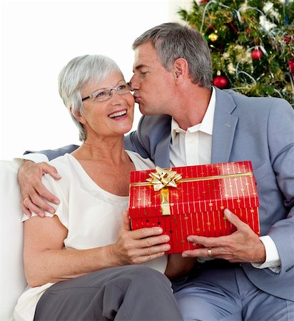 senior woman at christmas parties - Senior man giving a kiss and a Christmas present to his wife at home Stock Photo - Budget Royalty-Free & Subscription, Code: 400-04151109
