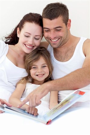 simsearch:400-05751566,k - Portrait of a little girl reading with her parents in bed Stock Photo - Budget Royalty-Free & Subscription, Code: 400-04151144