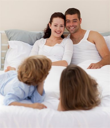 simsearch:400-04192370,k - Smiling family playing in bed Fotografie stock - Microstock e Abbonamento, Codice: 400-04151147