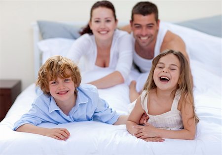 simsearch:400-04192370,k - Happy brother and sister having fun in bed with their parents Fotografie stock - Microstock e Abbonamento, Codice: 400-04151148