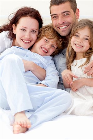 simsearch:400-04192370,k - Portrait of young family lying together in bed Fotografie stock - Microstock e Abbonamento, Codice: 400-04151150