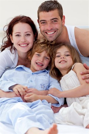 simsearch:400-04192370,k - Smiling family playing in bed Fotografie stock - Microstock e Abbonamento, Codice: 400-04151151