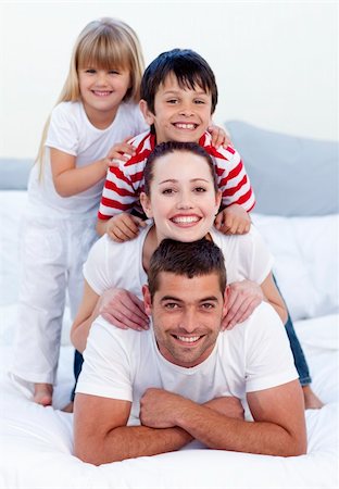 simsearch:400-04878558,k - Happy young parents and children playing in bed together Stock Photo - Budget Royalty-Free & Subscription, Code: 400-04151167