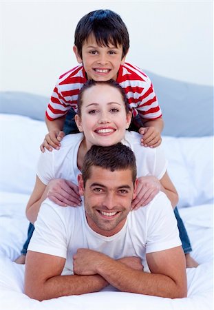 simsearch:400-04878558,k - Happy parents and son playing in bed together Stock Photo - Budget Royalty-Free & Subscription, Code: 400-04151172