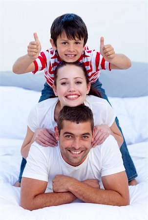 simsearch:400-04878558,k - Happy parents and son playing in bed with thumbs up Stock Photo - Budget Royalty-Free & Subscription, Code: 400-04151173