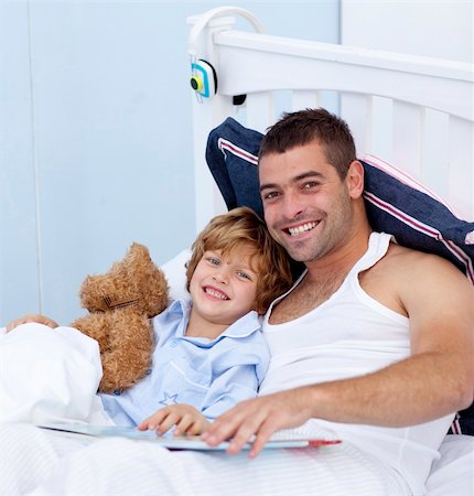 simsearch:400-05751566,k - Smiling father and son reading a book in bed together Stock Photo - Budget Royalty-Free & Subscription, Code: 400-04151222