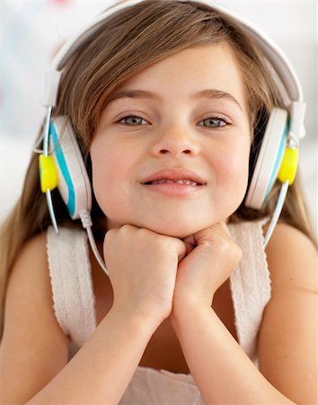 simsearch:400-05717354,k - Smiling little girl lying in bed listening to the music Stock Photo - Budget Royalty-Free & Subscription, Code: 400-04151240