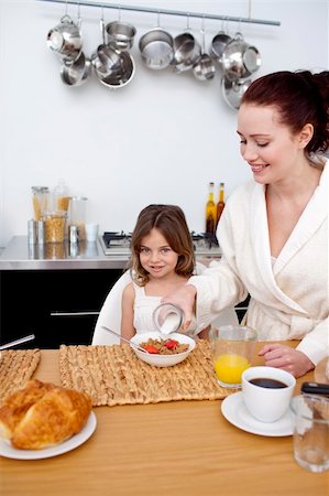 simsearch:400-04416091,k - Daughter and mother in kitchen eating breakfast Fotografie stock - Microstock e Abbonamento, Codice: 400-04151261