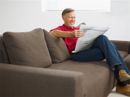 simsearch:6113-09241462,k - senior man reading newspaper at home and smiling Photographie de stock - Aubaine LD & Abonnement, Code: 400-04151346