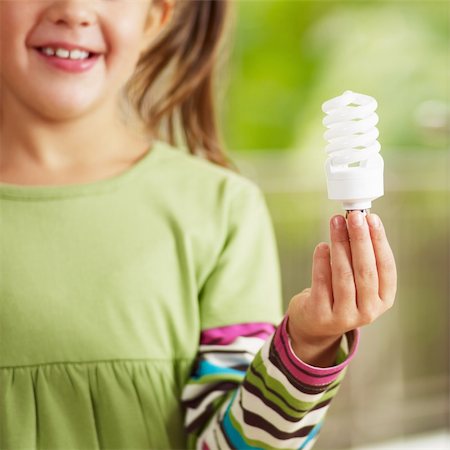 show girl bulb - Girl holding light bulb and smiling. Selective focus Stock Photo - Budget Royalty-Free & Subscription, Code: 400-04151358